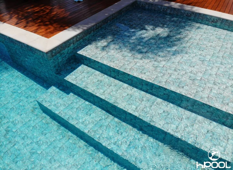 Degraus submersos e a textura do revestimento na entrada da piscina.