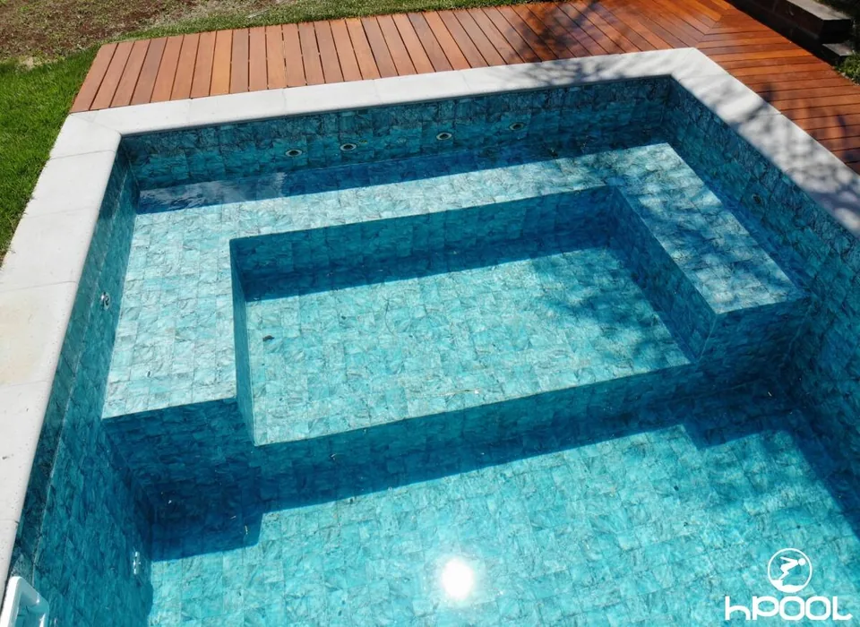 Detalhe do revestimento sob a água, com banco submerso e textura de pedra.