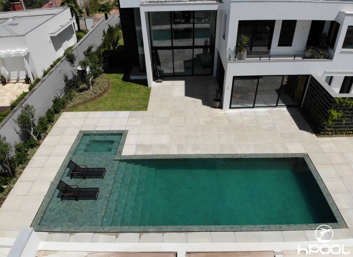 Vista aérea de piscina executada pela HPool em área de lazer residencial de alto padrão.
